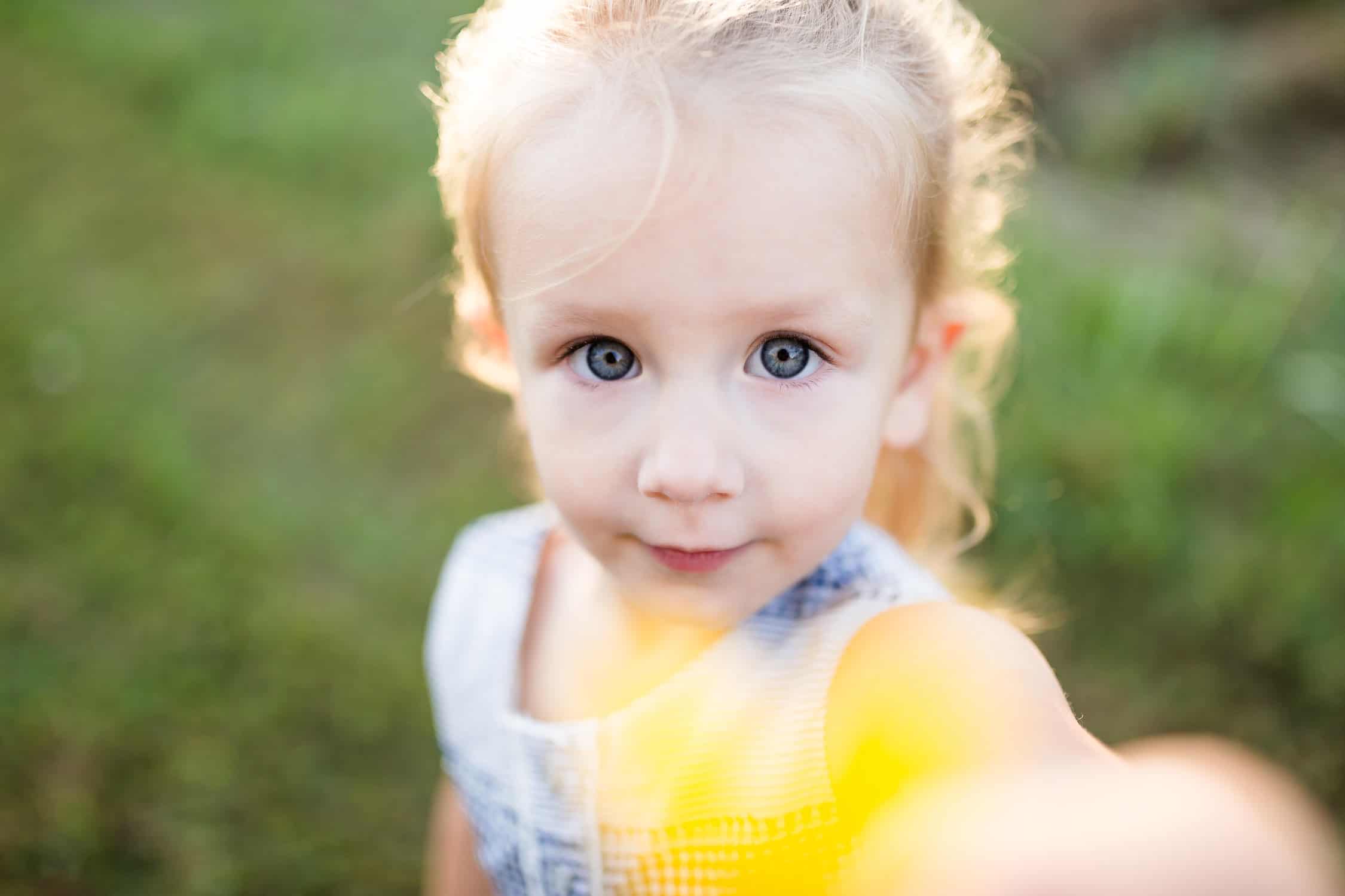 Kansas city child with yellow flower in a sunflower field